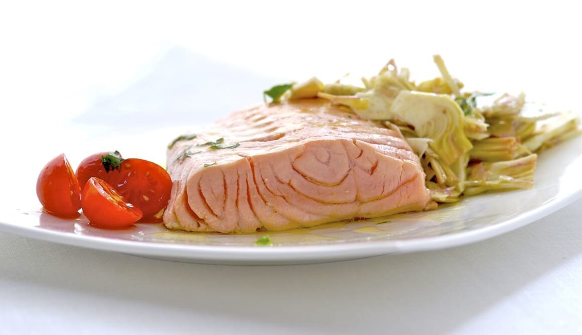 Salmone al forno con carciofi su erbe e limoni