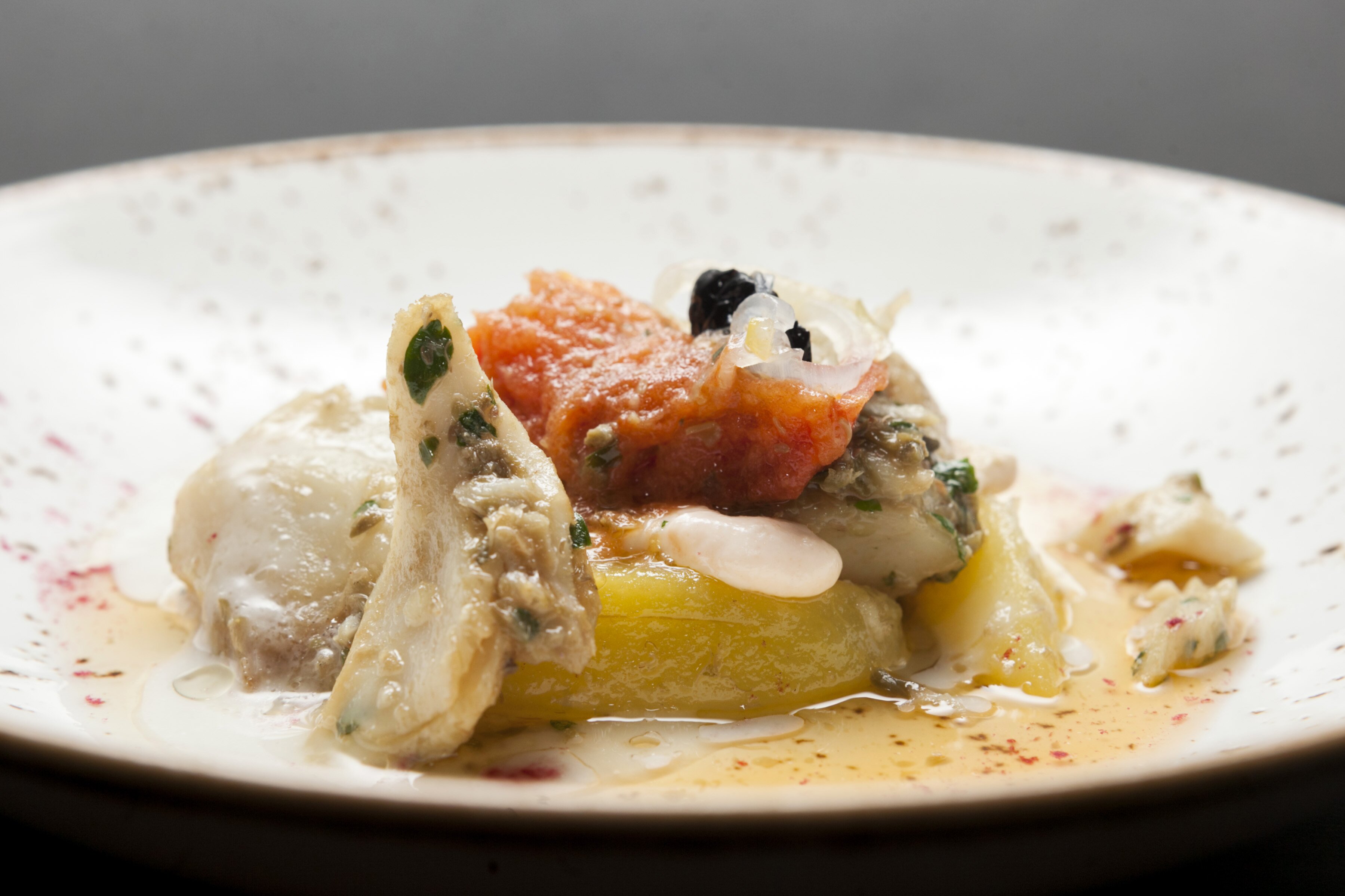 Stoccafisso di Norvegia quasi all’anconetana, patate, olive nere con salsa di cocco-lime e polvere di lampone