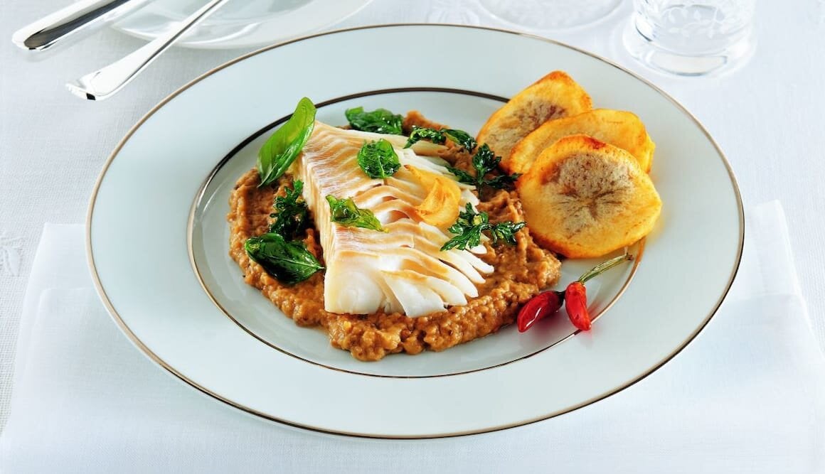 Baccalà di Norvegia sfogliato su purea di melanzane e bignè di patate con olive