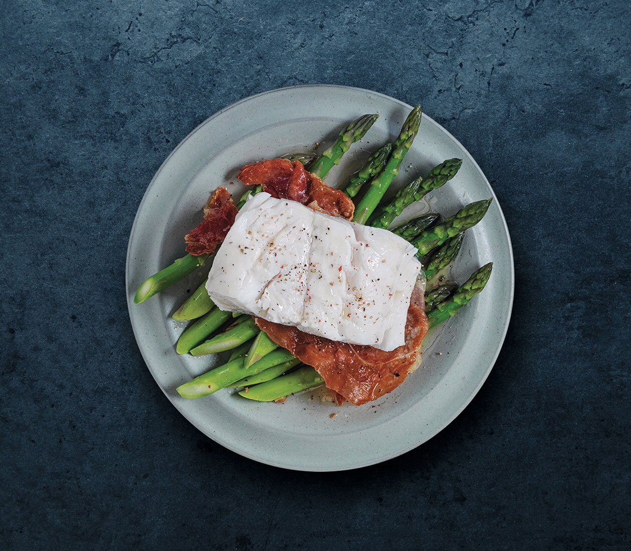 Skrei norvegese con asparagi e prosciutto crudo
